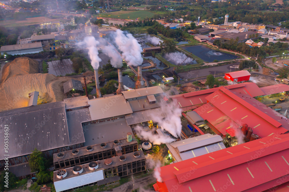 Aerial view of factory industry with smoke and toxic air from chimney in energy and pollution environment concept with city town landscape background.