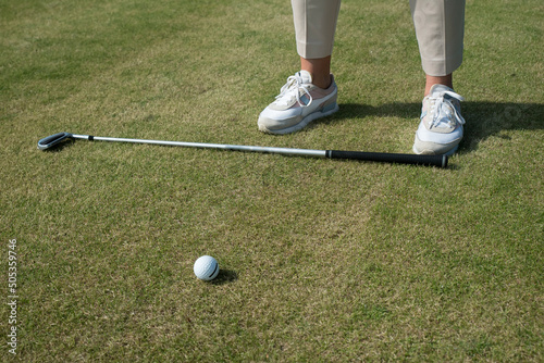 gra w golfa. kij do golfa leżący na trawie przed graczem.