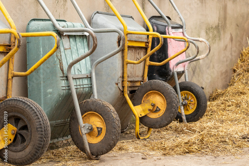 stacked upright farm wheel barrows