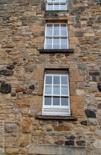 Beautiful old European Medieval era stone wall abstract  texture background  with modern windows 