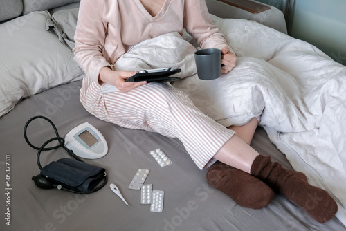 Medicine. The girl is sick at home in bed, next to pills, thermometer, medicines. Virus and temperature. Health care. Telemedicine, online doctor appointment
