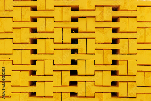 New yellow wooden formwork stacked in a warehouse in large stack. Materials for the construction and erection of concrete structures. wooden formwork made of plywood. photo