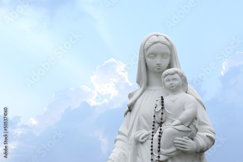 Fotomurale Beautiful statue of Virgin Mary and baby Jesus with rosary beads outdoors