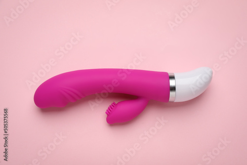 Vaginal vibrator on pink background, top view. Sex toy