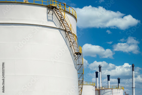 Carta da parati White oil storage tanks at petrol industrial zone, Industrial oil tanks in a refinery, White fuel storage tank against blue sky