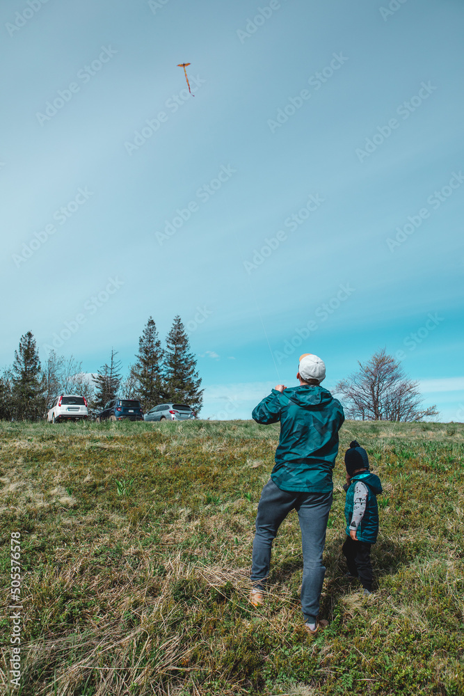 man with kids playing outdoors with kite man with kids playing outdoors with kite