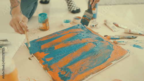 Couple pours paint on canvas to paint inside the house