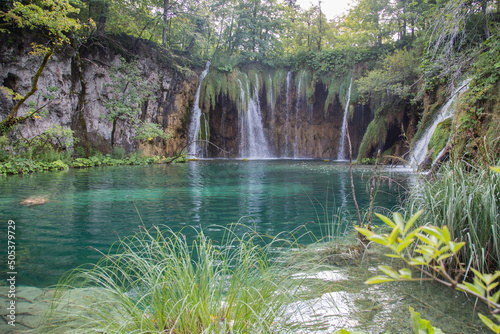 Plitvice Lakes National Park,Croatia, Europe:Waterfalls streaming into a beautiful pond with crystal clear turquoise water - surrounded by a natural finished biotope with characteristic endemic plants