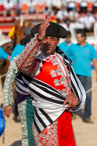 a bullfighter greets the president of the celebration at the beginning of a bullfight