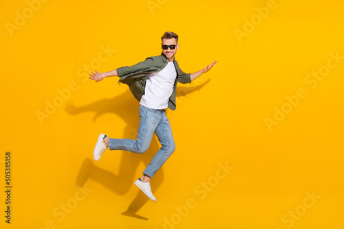 Full length body size view of attractive cheerful comic guy jumping fooling isolated over bright yellow color background