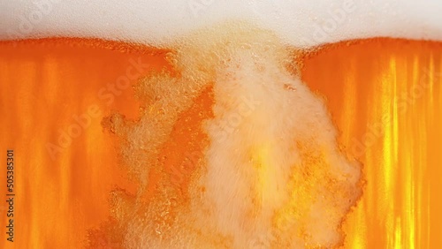 Super Slow Motion Shot of Pouring Fresh Beer into Glass with Foam at 1000fps. photo