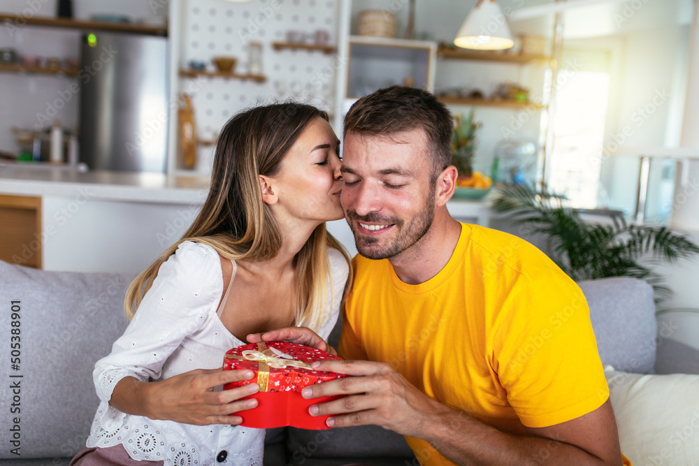 Happy couple with gift box hugging at home Happy couple with gift box hugging at home
