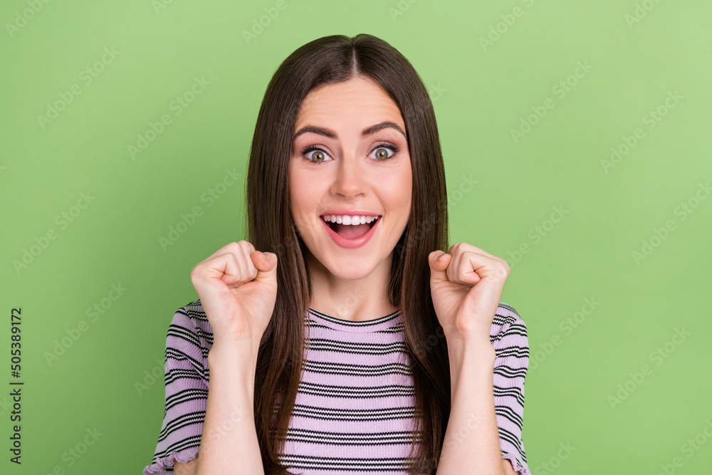 Portrait of attractive cheerful girly lucky brown-haired girl celebrating having fun isolated over bright green color background Portrait of attractive cheerful girly lucky brown-haired girl celebrating having fun isolated over bright green color background