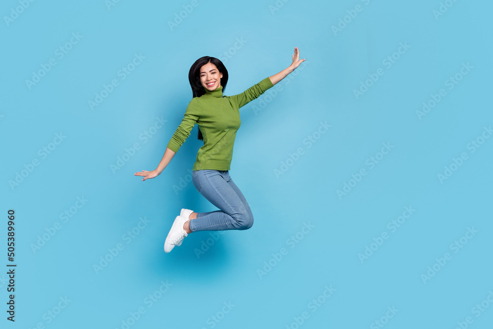 Full length body size view of attractive cheerful funky girl jumping rest having fun shop isolated over bright blue color background Full length body size view of attractive cheerful funky girl jumping rest having fun shop isolated over bright blue color background