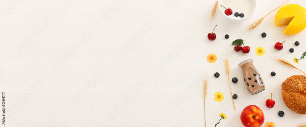 top view photo of dairy products over white wooden background. Symbols of jewish holiday - Shavuot top view photo of dairy products over white wooden background. Symbols of jewish holiday - Shavuot