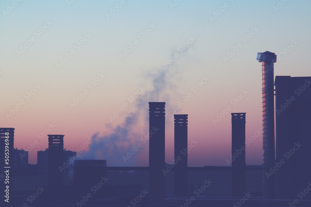 Chimeneas de un edificio moderno al amanecer en Madrid, España. Salida de aire caliente y vapor de agua procedente de la condensación del aire procedente de la calefacción del edificio en invierno. Chimeneas de un edificio moderno al amanecer en Madrid, España. Salida de aire caliente y vapor de agua procedente de la condensación del aire procedente de la calefacción del edificio en invierno.