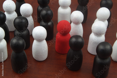 One red colored figure in crowd of black and white people figures. Talent and skills concept.