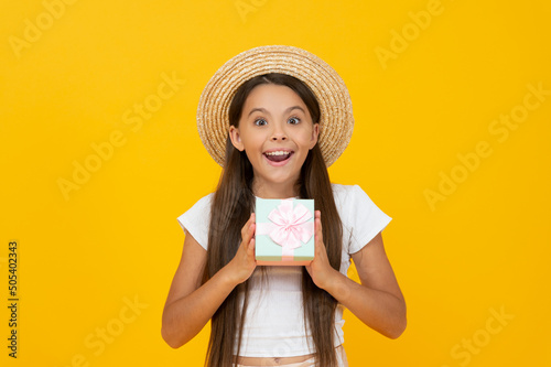 Fotografija amazed teen kid hold present box on yellow background