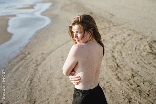 girl on a sandy beach with a bare back