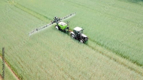 tractor with field sprayer sprays pesticides or fertilizer on a wheat field, insecticide, fungicide, herbicide, plant protection product, plant protection photo