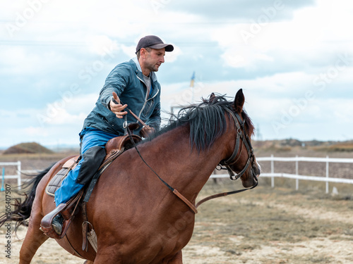 Portrait of a young person rider riding bay horse fast © Tetiana
