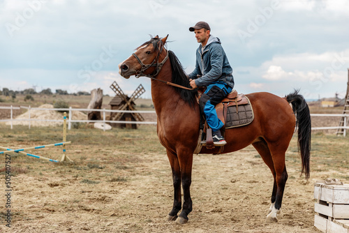Portrait of a 30-40 years old man farmer riding his horse .