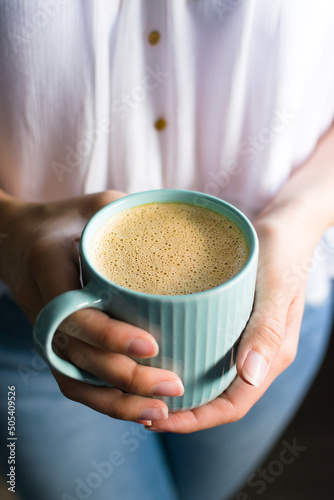 girl holding a cup of cashew coffee