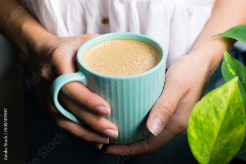 girl holding a cup of cashew coffee