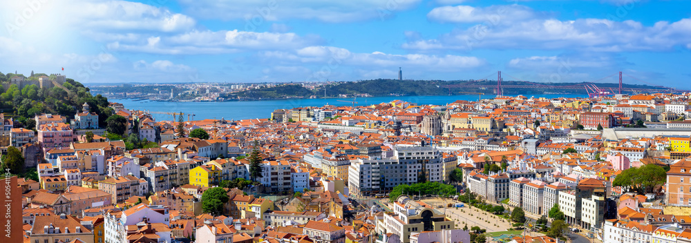 Panoramic view of the cityscape of Lisbon, Portugal, with Sao Jorge Castle and the red roofes of the Alfama district until the Tagus river on a sunny day