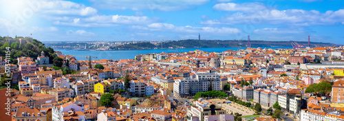 Panoramic view of the cityscape of Lisbon, Portugal, with Sao Jorge Castle and the red roofes of the Alfama district until the Tagus river on a sunny day