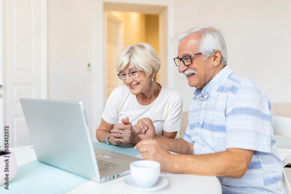 Senior couple is talking online via video connection on the laptop. Having nice time withfriends and family via video call.