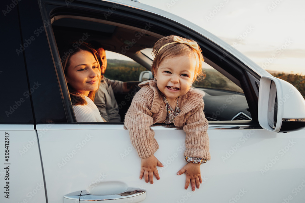 little Girl Looking Out of Car Window, Young Family with Baby Daughter on a Road Trip at Sunset
