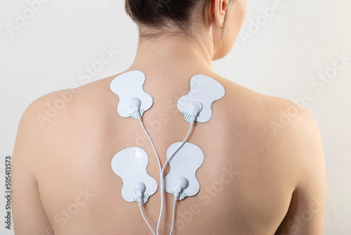 medical electric acupuncture massager on the body of a girl. Fat burning and health promotion. Physiotherapy, close-up photo