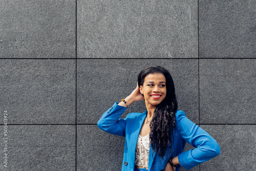 Cheerful ethnic woman in casual wear on street Cheerful ethnic woman in casual wear on street
