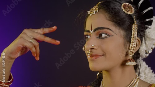 Close up head shot of bharatanatyam dancer doing eye moments or drishti bheda art form - concept of hobbies and traditional classical dancer. photo