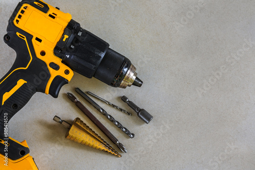 Cordless Hammer Drill/Driver with Drill bits on Cement board background