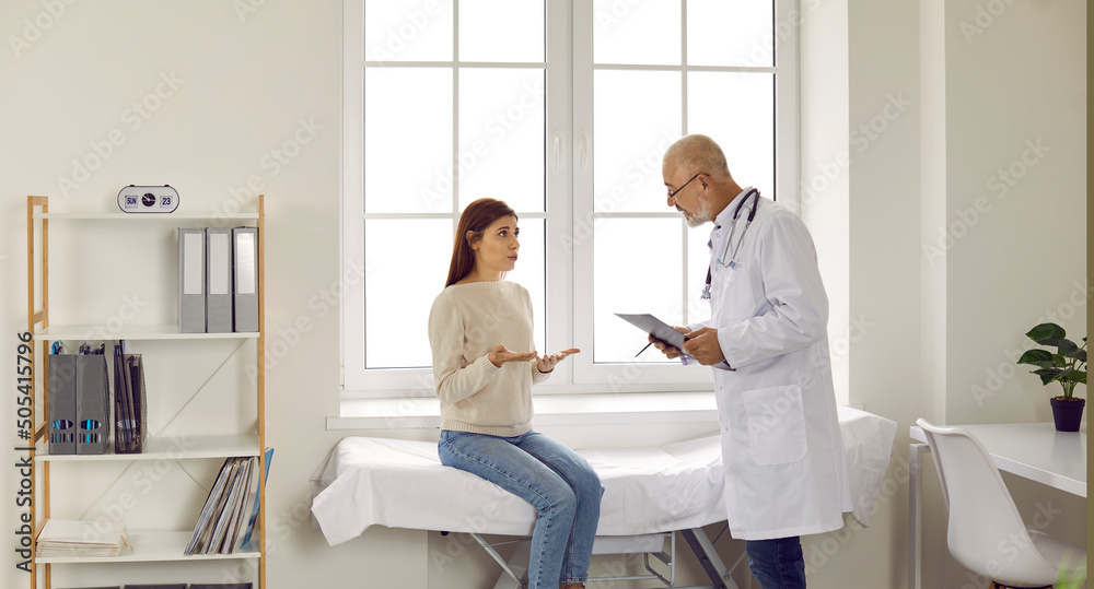 Banner narrow image of old male doctor consult sick young woman patient at hospital. Mature man GP or therapist talk with girl client in clinic. Medical consultation. Healthcare and medicine concept. Banner narrow image of old male doctor consult sick young woman patient at hospital. Mature man GP or therapist talk with girl client in clinic. Medical consultation. Healthcare and medicine concept.