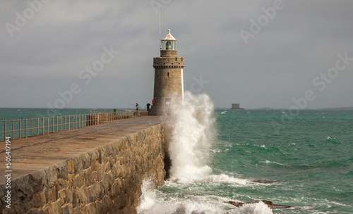 UK - Guernsey - The stormy surf hits the castle Cornet breakwater with lighthouse at the end in Saint Peter Port harbour photo