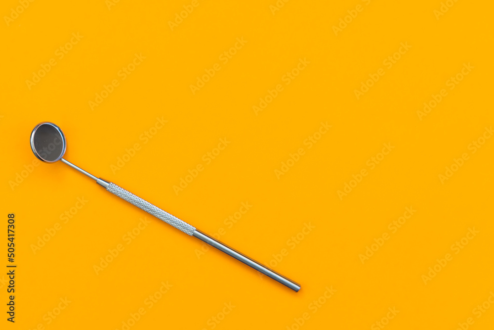 Dental mirror on an orange background. Medical tool Dental mirror on an orange background. Medical tool