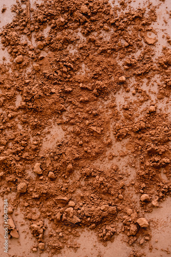 Top view of cocoa powder on brown background.