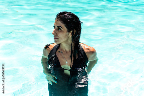 Woman swimming, splashing, and floating in pool