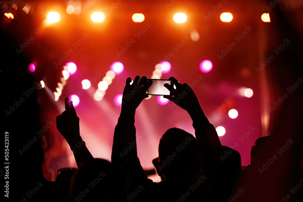 Hand with a smartphone records live music festival, Taking photo of concert stage, live concert, music festival. Hand with a smartphone records live music festival, Taking photo of concert stage, live concert, music festival.