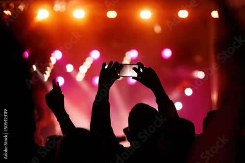 Hand with a smartphone records live music festival, Taking photo of concert stage, live concert, music festival.