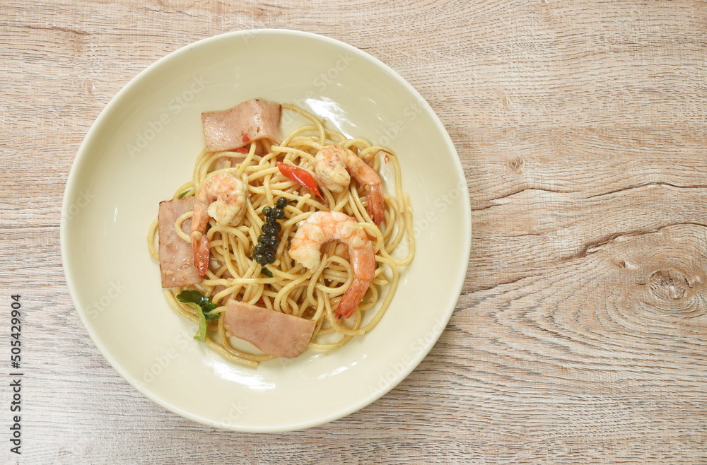 spicy stir fried spaghetti shrimp with slice ham pork and basil leaf on plate spicy stir fried spaghetti shrimp with slice ham pork and basil leaf on plate
