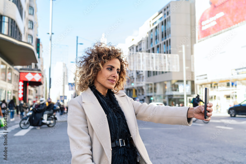 woman with afro hair in the city taking a portrait