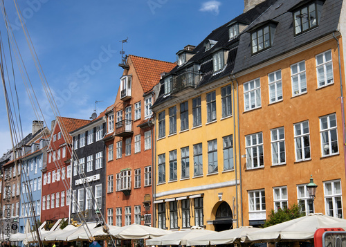  Nyhaven portin in the old city of Copenhagen, Denmark. Colorful houses against the blue sky. High quality photo