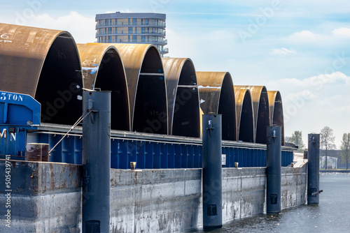 Closeup of barges with monopiles in an industrial harbor in Roermond photo