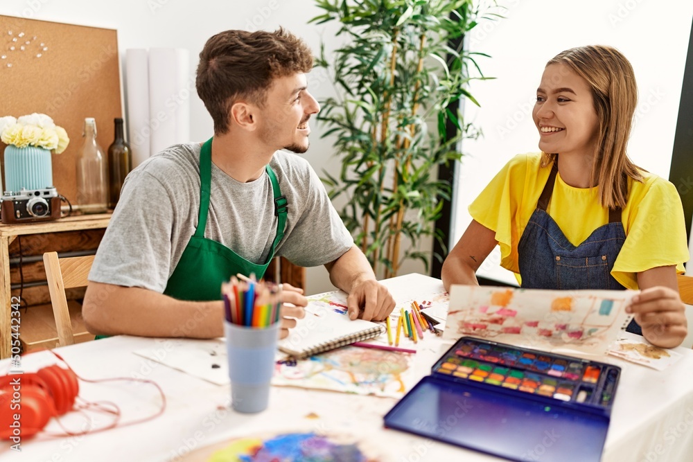 Young hispanic artist couple smiling happy drawing at art studio. Young hispanic artist couple smiling happy drawing at art studio.