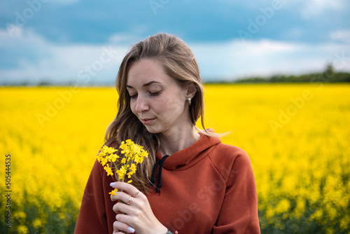 Ukrainian girl, portrait of a girl on a background of yellow rapeseed field, the background resembles the flag of Ukraine