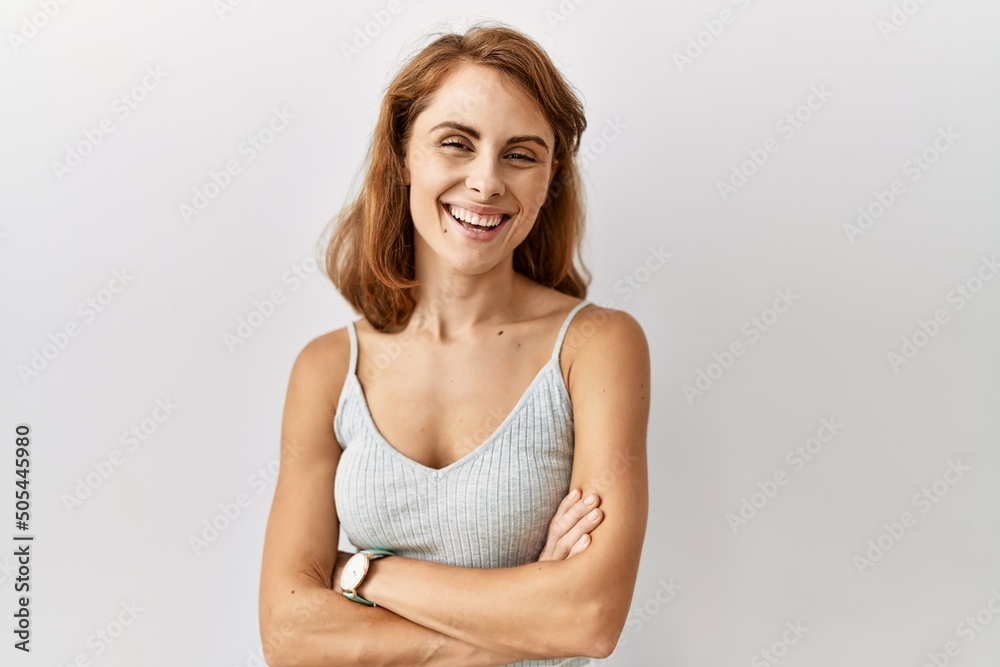 Beautiful caucasian woman standing over isolated background happy face smiling with crossed arms looking at the camera. positive person. Beautiful caucasian woman standing over isolated background happy face smiling with crossed arms looking at the camera. positive person.